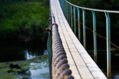 yaz aylarında ormanda küçük bir nehir üzerinde eski asma köprü, köprü elemanları