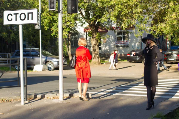 siyah iş elbisesi genç zarif kadın bir yaya geçidinde caddeyi geçer