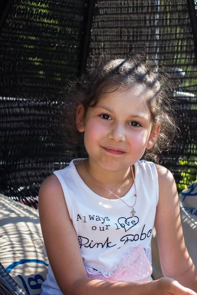 Uma Menina Está Descansando Uma Cadeira Vime — Fotografia de Stock