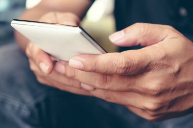 Akıllı telefon kullanarak, Closeup adam tutarak ve bir akıllı telefon dokunmadan eller