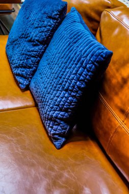 Deri koltuk üzerinde mavi yastık detayını kapatın