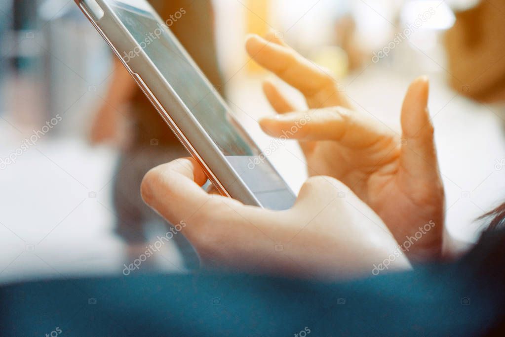 Closeup image of woman's hands holding and touching a smartphone