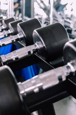 Spor malzemelerinin halterlerin ağırlığı, spor salonu arka planının görüntüsünü kapat  