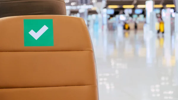 社会的距離 新しいコロナウイルスの拡散を防ぐための社会的距離プロトコルに関するシンボルがマークされた空港の出発エリアの空の椅子の行 タイのCovid — ストック写真