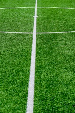 Yeşil çimenli ve beyaz çizgili futbol sahası, spor arka planı.