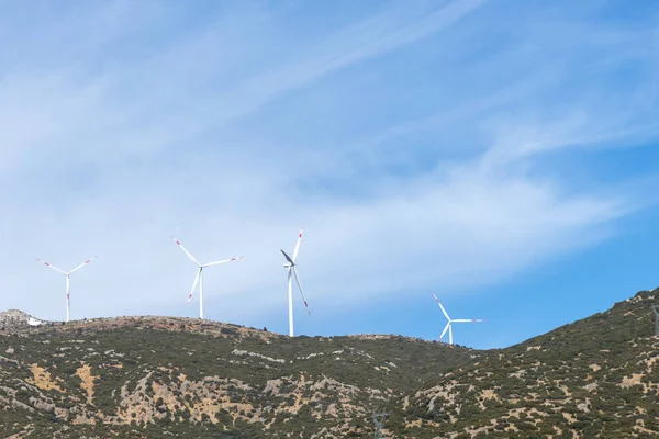 Wind turbines in operation on mountain.