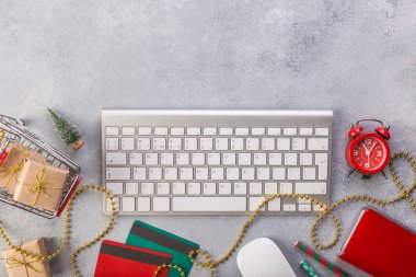 Üstten görünüm online - çevrimiçi kavramı alışveriş online Noel hediye. Yukarıdan kopya alanı ile görüntüleyin. Zaman kavramı kaydetmek. Kırmızı saat, mavi defter, klavye, hediye sepeti, vredit kartları.