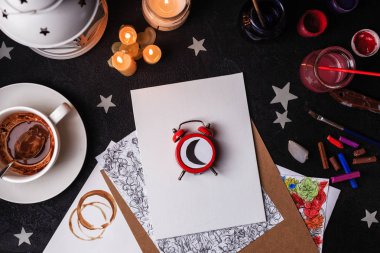 Çizim Araçları'nda sanat stüdyosu. Konsept: uykulu ressam. Boş sayfa ortasında kırmızı bir saat gece zaman ay gösterilen rahatsız etmeyin. Boya fırçaları yağlı boya darbeleri karışımı ve kağıt mockup paletinin yanındaki fotoğrafı üstten görünüm.