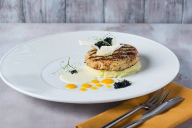 Patates püresi sosu gelen beyaz plaka sarı operator Tarih ile süslenmiş balık pirzola