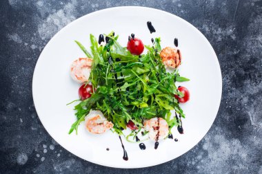 Taze salata tabağı gri arka plan üzerinde roket salata karides, yakın çekim. Sağlıklı gıda.