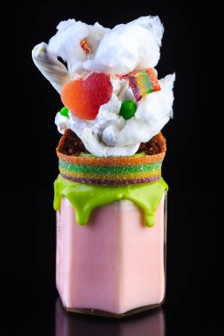 Süt parlak kokteyl cam tatlılar ve cholocale yansıması ile siyah süslenmiş krem şanti ile