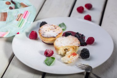 Süzme peynirli gözleme, syrniki, lor börek Beyaz ahşap arka plan beyaz plaka üzerinde taze çilek ile