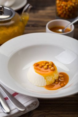 beyaz tabak restoranda see-buckthorn portakal soslu tatlı pana cotta