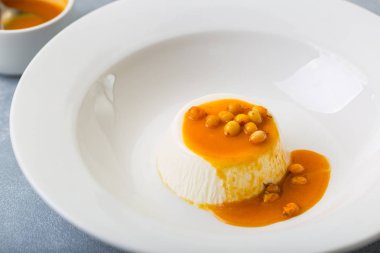 beyaz tabak restoranda see-buckthorn portakal soslu tatlı pana cotta