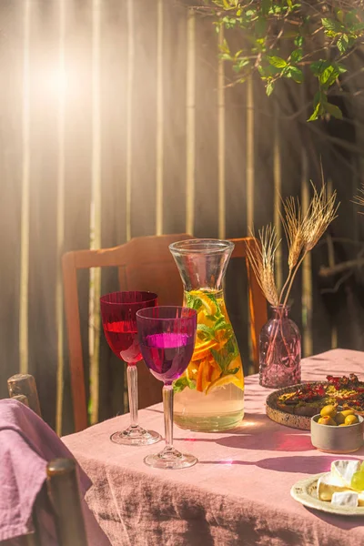 庭の夏のピクニックの太陽の光の外にバラのテーブルクロスとテーブルでレモネードの2カラフルなグラス — ストック写真