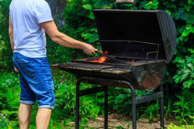 Beyaz t-shirt erkekler Barbekü yer yangın hazırlanıyor