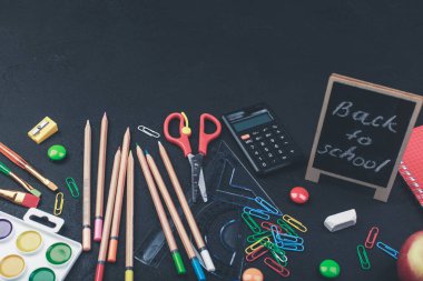 Siyah tahta arka planda okul malzemeleri okula geri renkli