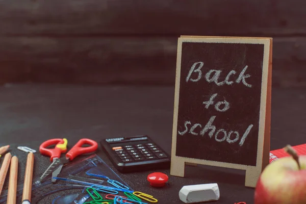 School supplies on black board background colorful back to school