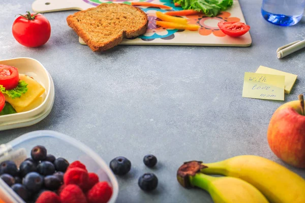 Lunchboxes with sandwiches and different products on grey background — Stock Photo, Image