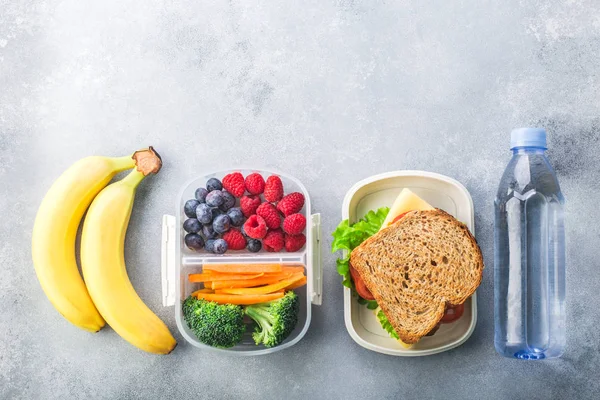 회색 테이블에 샌드위치 야채 물 아몬드와 과일을 갖춘 학교 점심 상자 건강한 — 스톡 사진