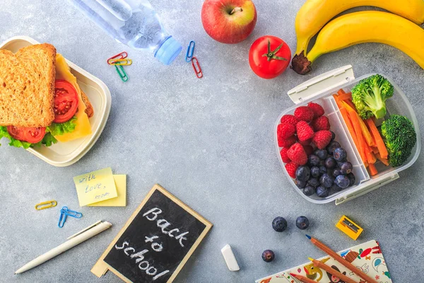 Lancheiras com sanduíches e diferentes produtos em fundo cinza — Fotografia de Stock