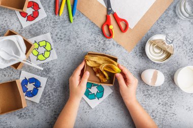 Kız elleri gri arka plan renkli kağıt içinde geri dönüşüm oyunu yapıyoruz