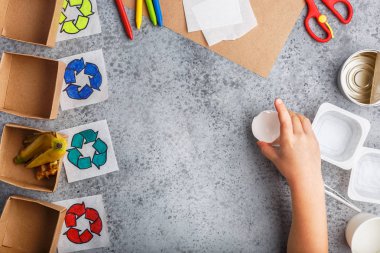 Kız elleri gri arka plan renkli kağıt içinde geri dönüşüm oyunu yapıyoruz