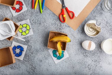 Kız elleri gri arka plan renkli kağıt içinde geri dönüşüm oyunu yapıyoruz