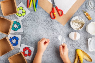 Kız elleri gri arka plan renkli kağıt içinde geri dönüşüm oyunu yapıyoruz