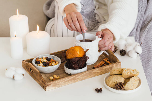 Девушка пьет горячий чай с печеньем, орехами, кексами
