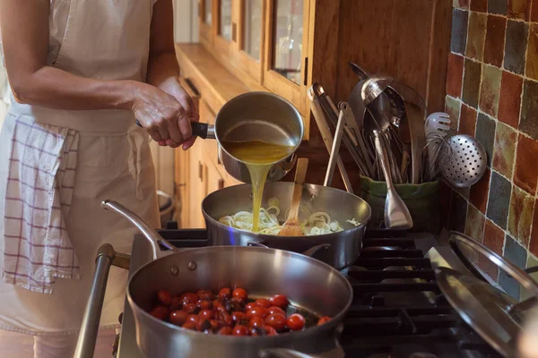 Пан с карамелизированными помидорами вишневый процесс приготовления пищи и добавления ингредиентов руки — стоковое фото