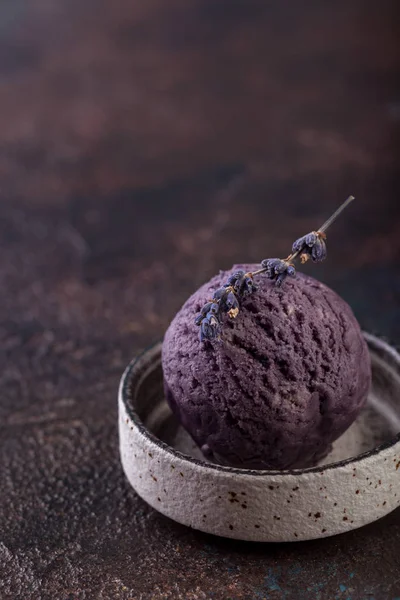 lavender ice-cream in round grey plate on brown background