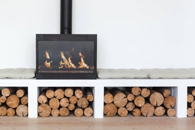 İskandinav tarzında bir odun yığını ile parlak bir odada bir şömine ile rahat iç 