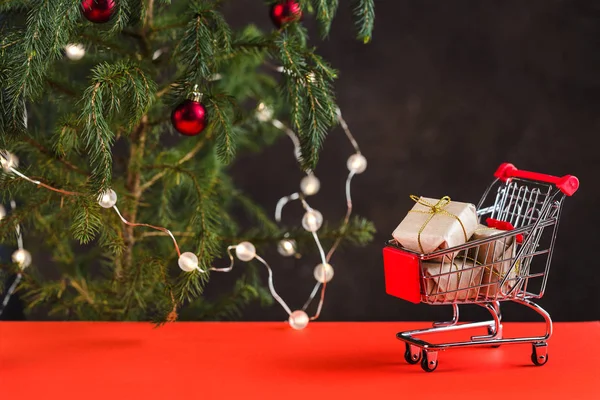 Mutlu Yıllar 2020. Noel kompozisyonu. Kırmızı bir masada oyuncaklar ile bir Noel ağacının yanında hediye kutuları ile Mini arabası — Stok fotoğraf