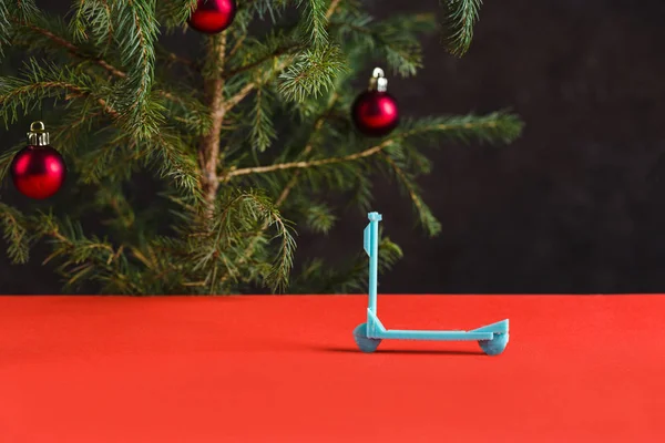 Frohes neues Jahr 2020. weihnachtliche Komposition. Mini-Roller auf rotem Tisch mit Weihnachtsbaum und Spielzeug — Stockfoto