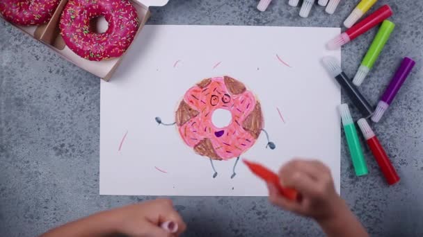 Anak-anak tangan menggambar donat mawar dengan pena felt-tip pada HD abu-abu — Stok Video