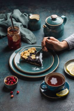 Sonbahar masasında bir dilim çilekli turta ve bir fincan sıcak çayla çay partisi. Üst görünüm