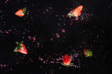 Böğürtlen patlaması Çilek ve su sıçraması. Siyah arkaplan