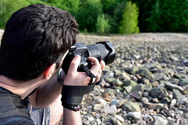 Profesyonel fotoğraf makinesiyle fotoğraf çeken bir adam dağın tepesinde güzel bir manzara. 