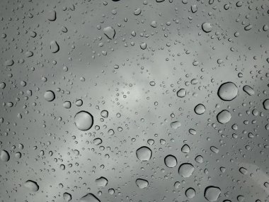 Pencere gözlük yüzeyi ile bulutlu arka plan üzerinde bulutlu arka plan izole yağmur damlaları doğal desen yağmur damlaları 