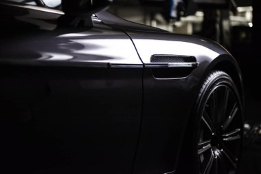 Modern lüks, gri, metalik bir arabanın arka farları, araba bakım konsepti garajda.