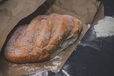 sadece soba gelen masada ekmek. Flour.bread kraft kağıt ile pişmiş taze pişmiş ekmek.