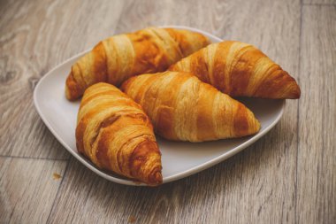 Gıda fotoğraf Croissant.Delicious kruvasan ahşap bir masa üzerinde kare beyaz tabakta zengin çeşitli.