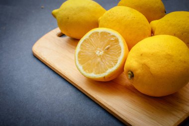 İştah açıcı limon, karanlık bir arka plan üzerinde bir ışık ahşap tahta üzerinde bir kesik.