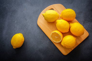 İştah açıcı limon, karanlık bir arka plan üzerinde bir ışık ahşap tahta üzerinde bir kesik.