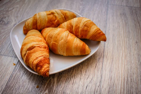 豊富な木製のテーブルの上の正方形の白い皿の上の食べ物写真 Croissant Delicious クロワッサン — ストック写真