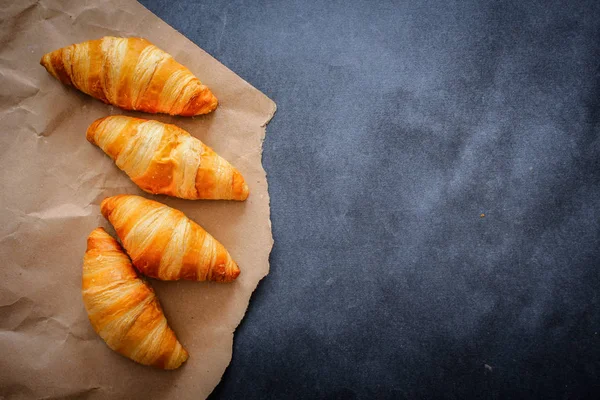 豊富な暗い対照的な背景に茶色のクラフト ペーパーの食品写真 Croissant Four クロワッサン — ストック写真