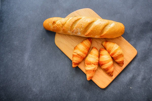 Pão Francês Quatro Croissants Uma Placa Corte Madeira Papel Artesanal — Fotografia de Stock