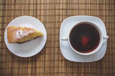 Erik sünger kek üzerine bir fincan çay bir saman yatak üzerinde