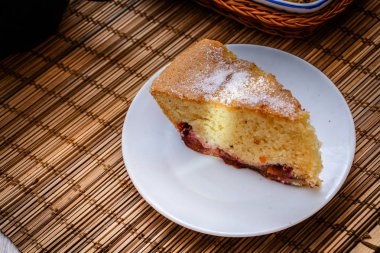 bir dilim kek yuvarlak beyaz plaka üzerinde